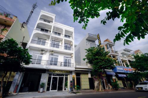 a tall white building on a city street at The Fancy House in Quy Nhon