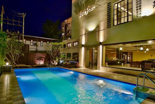 a swimming pool in front of a building at night at Thapaeplacehotel in Chiang Mai