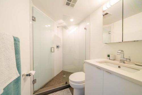 a white bathroom with a toilet and a shower at Sunset Beach Walk 2BD+2BA+1PRK Yaletown in Vancouver