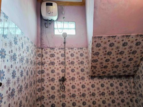 a bathroom with a shower in the corner of the wall at Jogo Segoro Homestay Mitra RedDoorz near Pantai Sundak Gunungkidul in Ngandong