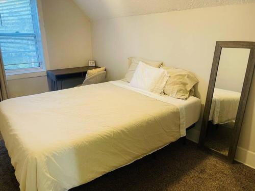 a bedroom with a white bed with a mirror at Modern Farmhouse on Kent Street in Saint Paul