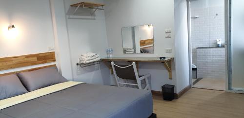 - une chambre avec un lit et un bureau avec un miroir dans l'établissement Little Guest House Hotel, à Chiang Mai