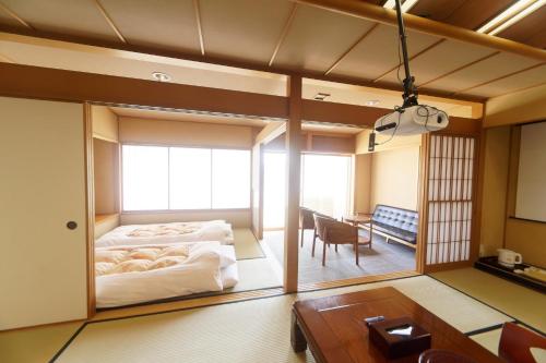 Cette chambre comprend un lit, un bureau et une table. dans l'établissement 熱海の隠れ里, à Atami