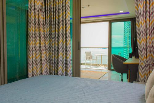 Schlafzimmer mit einem Bett und Meerblick in der Unterkunft Wongamat Tower Condominium in Pattaya North