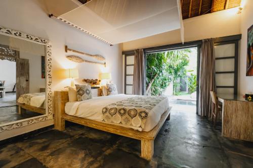 1 dormitorio con cama y espejo grande en Indiana Kenanga Boutique Hotel & Spa, en Nusa Lembongan