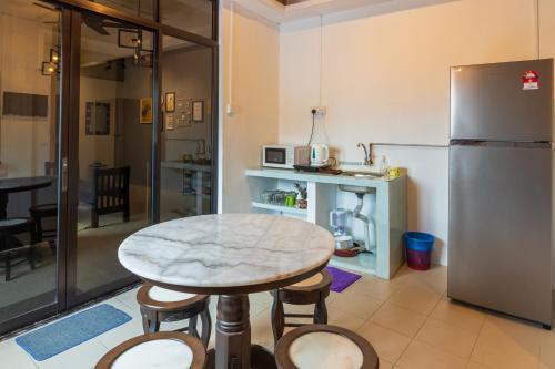 eine Küche mit einem Marmortisch und einem Kühlschrank in der Unterkunft Mac Inn 94 in George Town