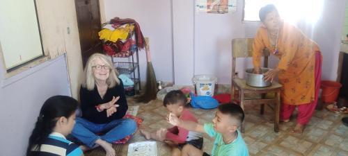 a group of children sitting on the floor in a room at Laxmi Homestay with main square view in Bhaktapur