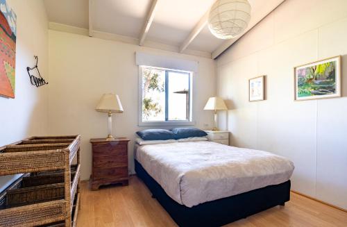 1 dormitorio con cama y ventana en Earl's Place Gracetown Beach Shack, en Gracetown