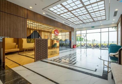 a lobby with chairs and tables and a glass ceiling at Apartment 1BR-FL22th-R103 Building-Vinhome Ocean Park in Hanoi