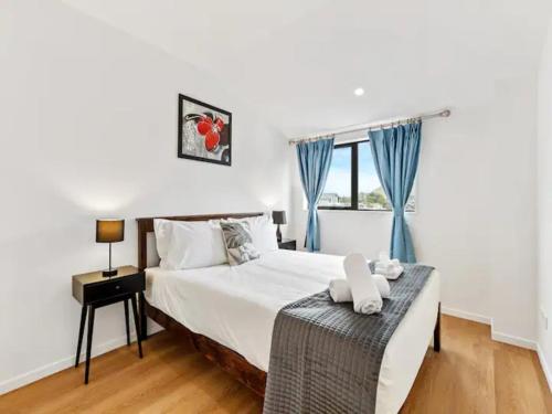 een slaapkamer met een bed en een raam bij Stunning Three Bedroom Townhouse with Free Parking in Auckland