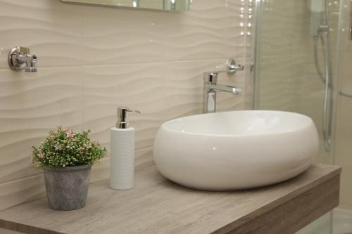 a white sink sitting on a counter in a bathroom at Apartments Rada - 150 m from the sea in Donje Selo