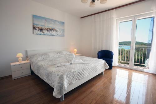 ein Schlafzimmer mit einem Bett und einem großen Fenster in der Unterkunft Apartments Rada - 150 m from the sea in Donje Selo