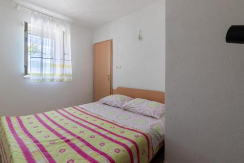 a bedroom with a bed and a window at Holiday home Branko - large terrace in Postira