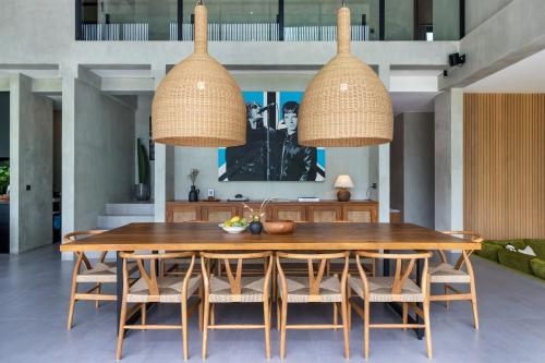 a dining room with a wooden table and chairs at Villa Oasis Bali in Dalung