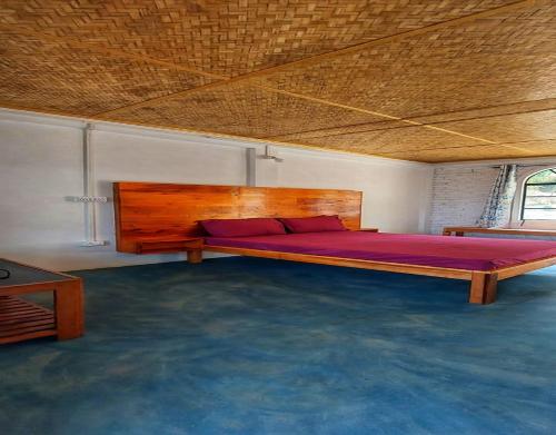 1 dormitorio con 1 cama grande de madera en una habitación en Rongong Farmstay by StayApart, en Māngwa