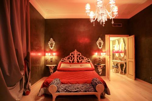 a bedroom with a red bed and a chandelier at Hotel Columbia Wellness & Spa in Montecatini Terme