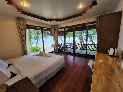 Un dormitorio con una cama con vista al mar. en Morning Star Resort, en Baan Tai