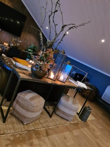 a living room with a table and a couch at Mysig lägenhet med öppen planlösning på hästgård. in Ljung