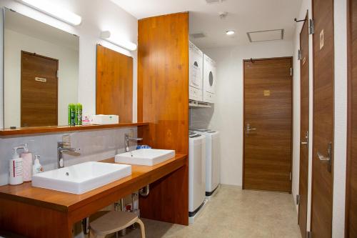een badkamer met 2 wastafels en een aanrecht met een spiegel bij Guest House Siesta in Tokyo