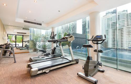 a gym with cardio machines and a swimming pool at Admiral Premier Bangkok in Bangkok