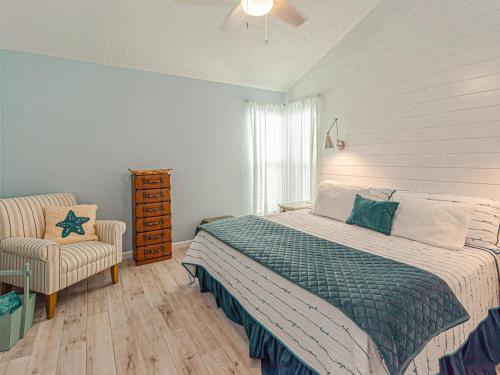 a bedroom with a bed and a chair at Kontiki Bayfront Condo 405 in Rockport