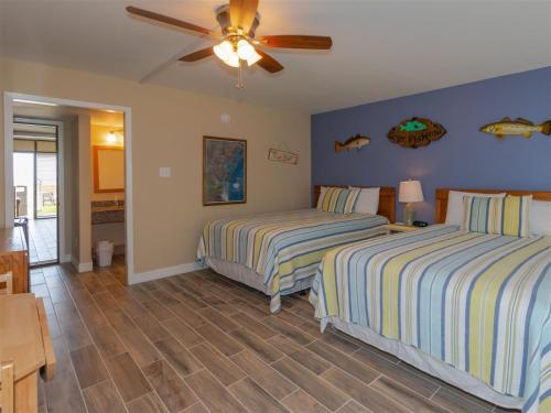 a bedroom with two beds and a ceiling fan at LR 117 - Gone Fishing in Rockport