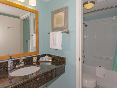 a bathroom with a sink and a mirror and a toilet at LR 121 - Gone Coastal in Rockport