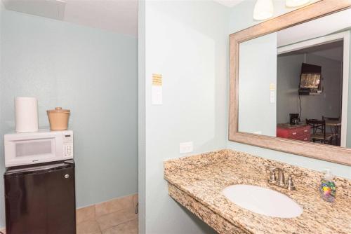 a bathroom with a sink and a mirror and a refrigerator at LR 115 - Rockport Breeze in Rockport