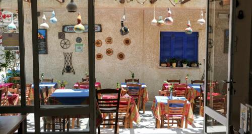 a restaurant with tables and chairs in a room at Mirtos Hotel in Myrtos