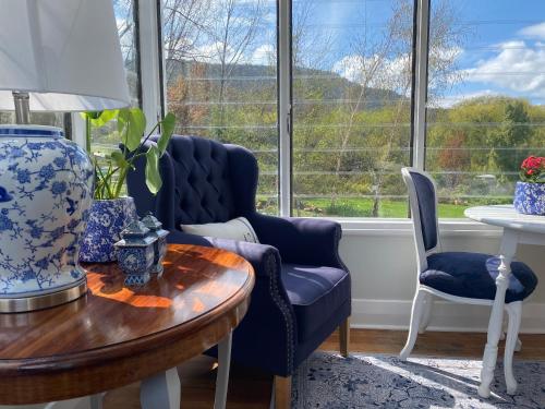 Explorers Lodge في نيو نورفولك: غرفة معيشة مع كراسي زرقاء وطاولة