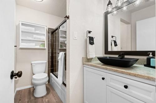 a bathroom with a black sink and a toilet at Sea La Vie in Rockport