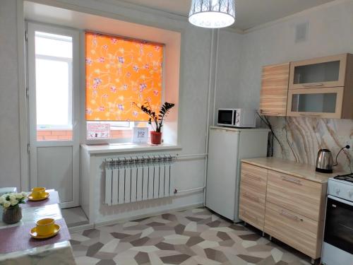a kitchen with an orange window and a sink and a stove at ЖК ПРЕСТИЖ 1 комнатная квартира in Kokshetau