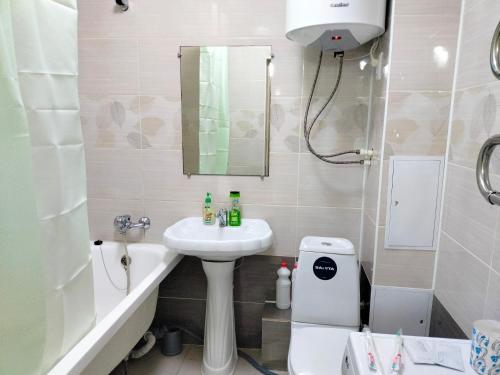 a bathroom with a sink and a toilet and a mirror at ЖК ПРЕСТИЖ 1 комнатная квартира in Kokshetau
