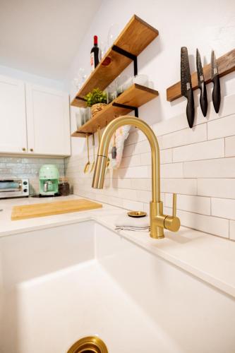 a kitchen sink with a gold faucet at Sohana Lifestyle Apartment I Leeven's Home I Kona in Kailua-Kona
