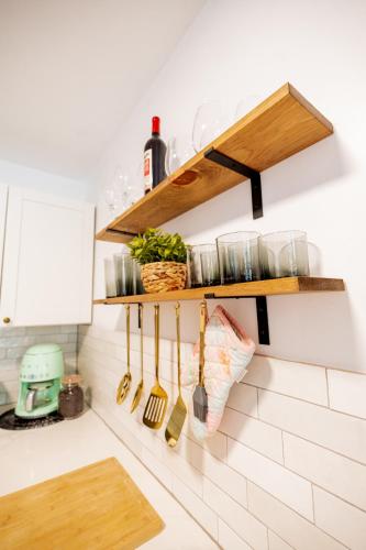 a kitchen with wooden shelves and utensils on the wall at Sohana Lifestyle Apartment I Leeven's Home I Kona in Kailua-Kona