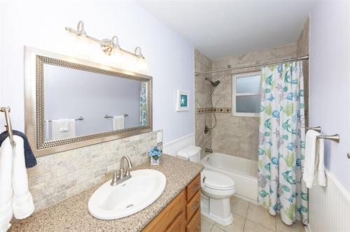 un bagno con lavandino, WC e specchio di Trout Tank a Rockport