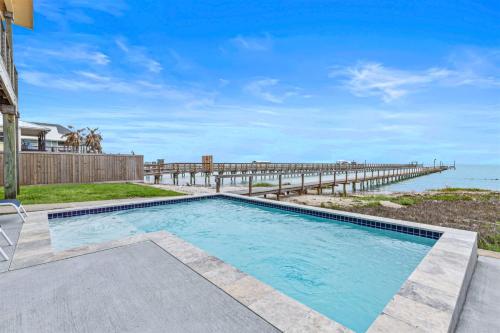 a swimming pool with a pier in the background at The Cats Meow in Rockport