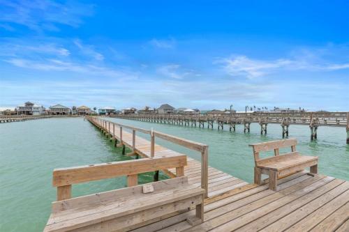 a wooden pier with a bench on the water at The Cats Meow in Rockport