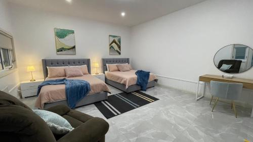 a living room with two beds and a mirror at Spacious Villa Holiday Staycation in Canterbury East of Melbourne in Balwyn