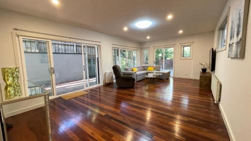 a living room with a couch and a table at Spacious Villa Holiday Staycation in Canterbury East of Melbourne in Balwyn