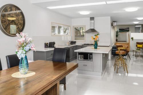 a kitchen with a vase of flowers on a table at Spacious Villa Holiday Staycation in Canterbury East of Melbourne in Balwyn