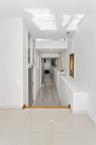 a hallway in a building with white walls and white floors at Spacious Villa Holiday Staycation in Canterbury East of Melbourne in Balwyn
