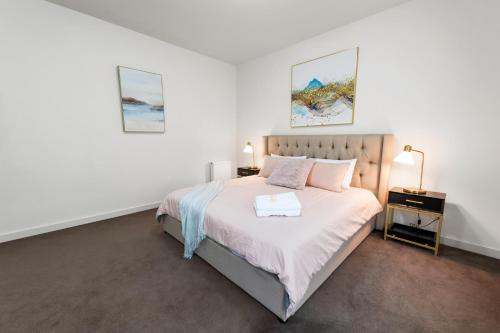 a bedroom with a large bed and a night stand at Spacious Villa Holiday Staycation in Canterbury East of Melbourne in Balwyn