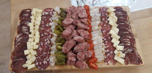 a cutting board with different types of cheese and grapes at Francek house Podčetrtek in Buče