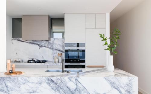 a kitchen with marble countertops and a vase with a plant at The Langham, Gold Coast and Jewel Residences in Gold Coast