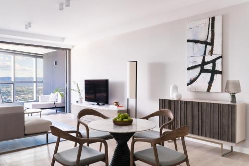 a living room with a table and chairs at The Langham, Gold Coast and Jewel Residences in Gold Coast