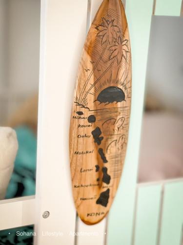 a wooden surfboard sitting on top of a shelf at Sohana Lifestyle Apartment I Leeven's Home I Kona in Kailua-Kona