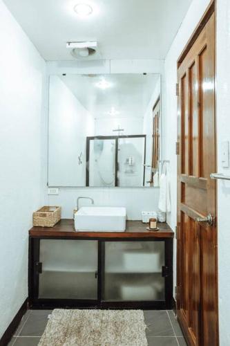 a bathroom with a sink and a large mirror at BayayTagoSiargao in General Luna