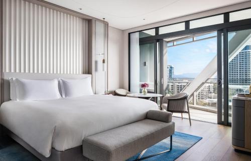 a bedroom with a white bed and a large window at The Langham, Gold Coast and Jewel Residences in Gold Coast