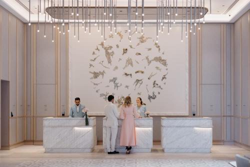 a group of people standing at a bar in a lobby at The Langham, Gold Coast and Jewel Residences in Gold Coast